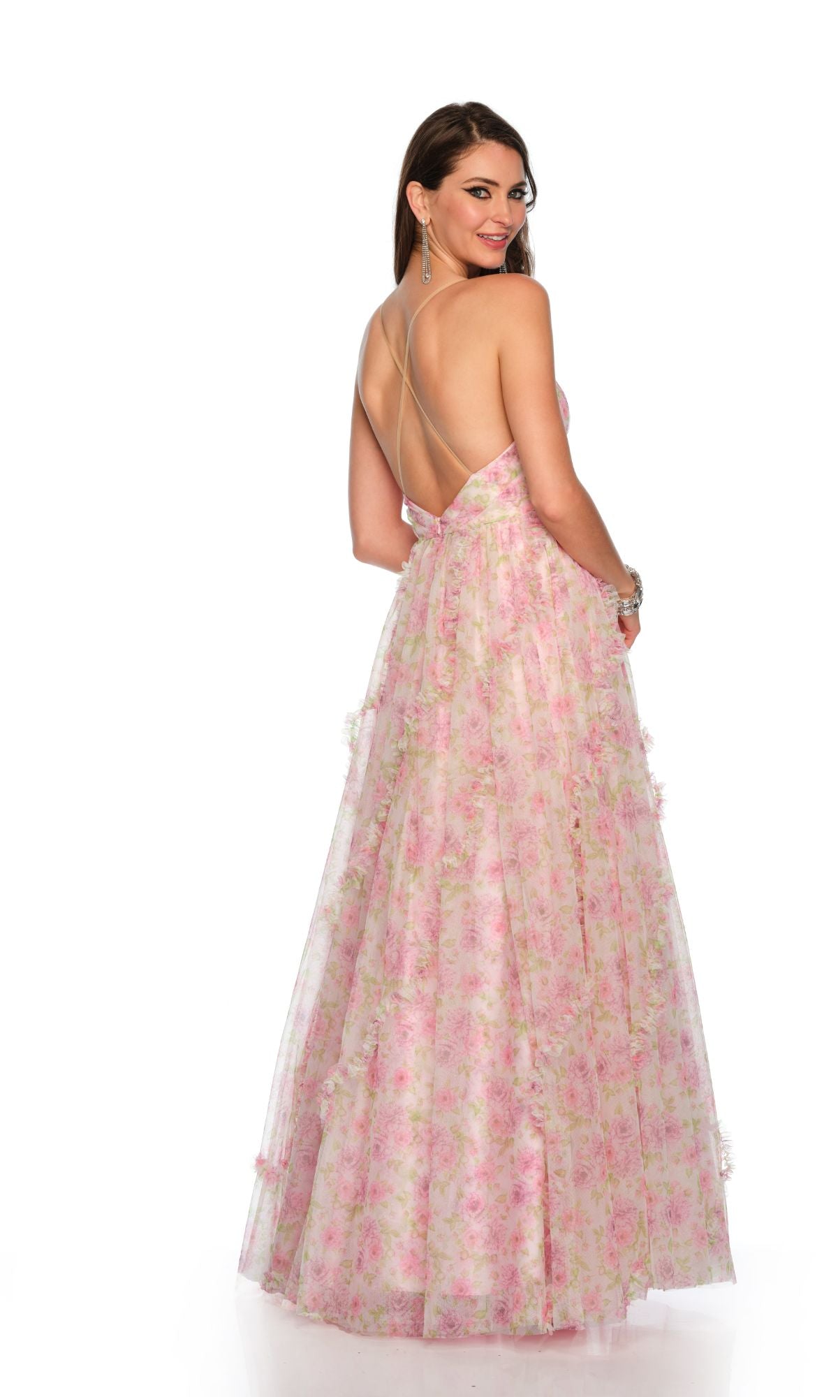 A woman poses in the Long Formal Dress 11590 by Dave and Johnny, a pastel pink floral A-line dress with a low open back and thin crisscross straps, standing against a white background.